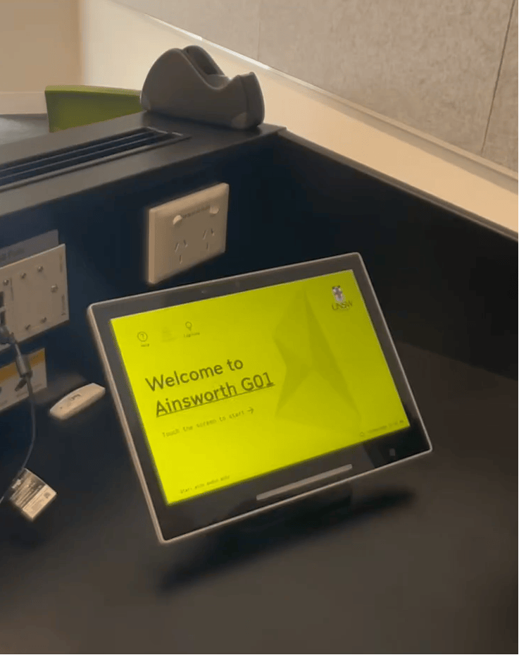 Digital display on a desk with 'Welcome to Ainsworth G01' text