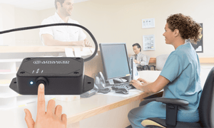 Compact PoE-powered Smart IP Button with SIP integration, installed beneath table.